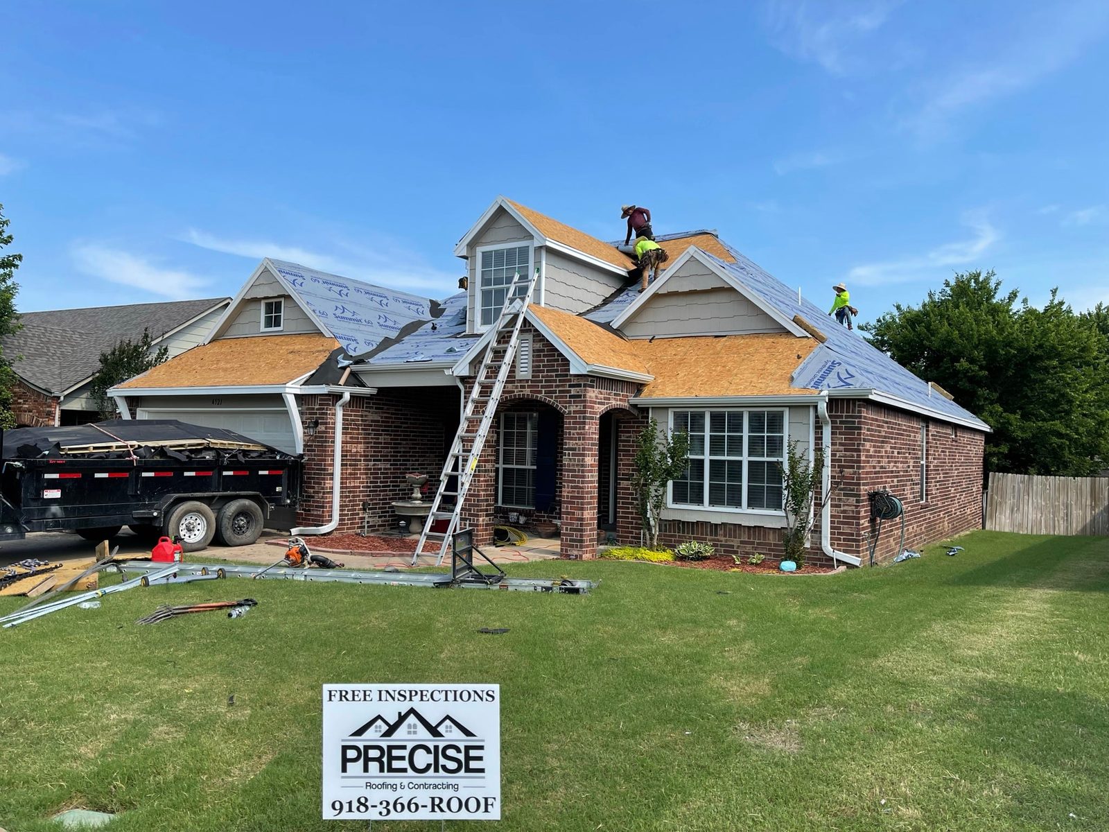 Precise Roofing crew working on a home, with a Precise yard sign in the lawn